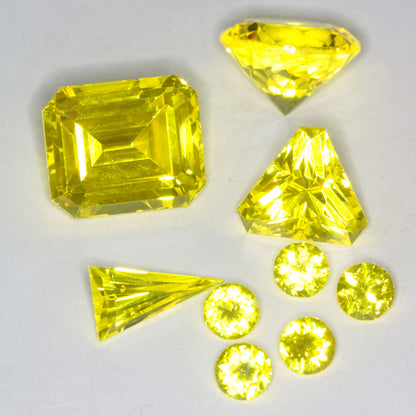 Several Faceted Cerium GAGG gems on a white background