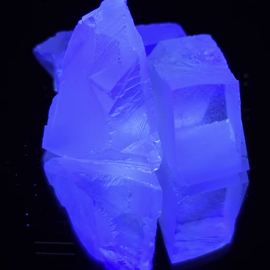 CaF2:Eu crystals spinning on a turntable, showing the bright blue fluorescence under UV light