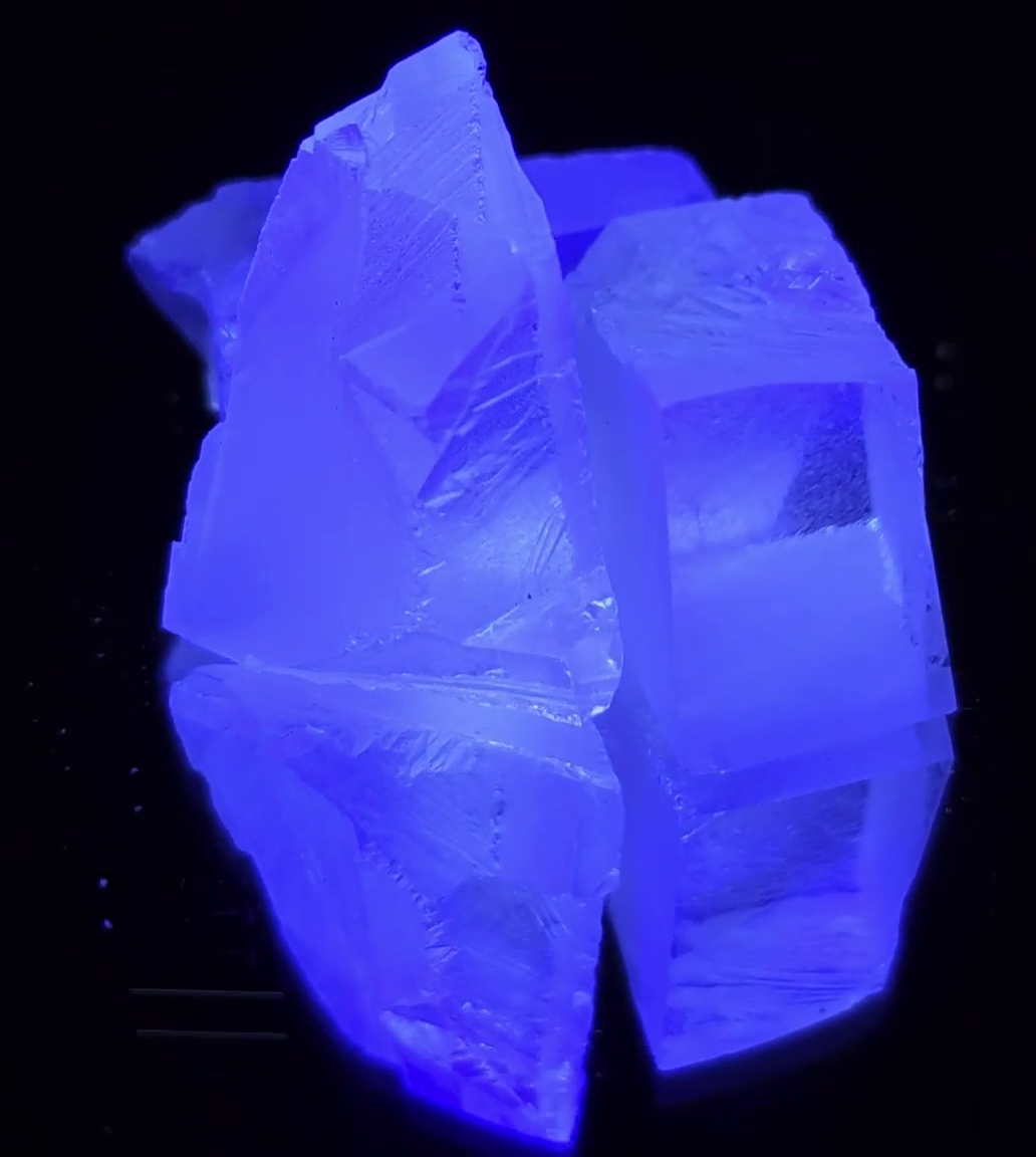 CaF2:Eu crystals spinning on a turntable, showing the bright blue fluorescence under UV light